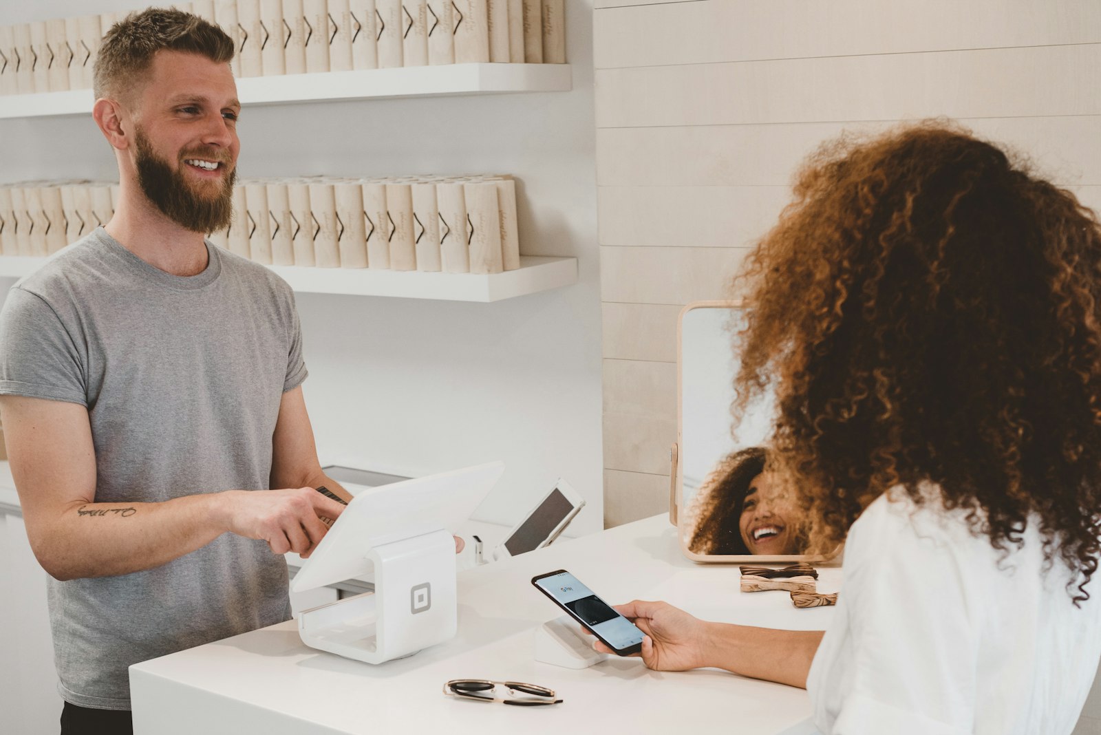 Merchant at a counter completing a payment with a customer