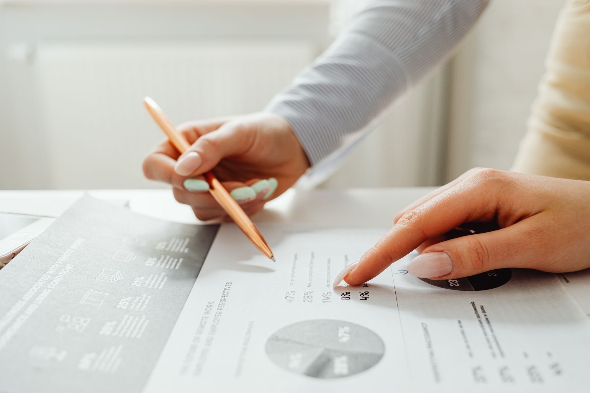 Close-up of hands pointing at percentages on a printed chart